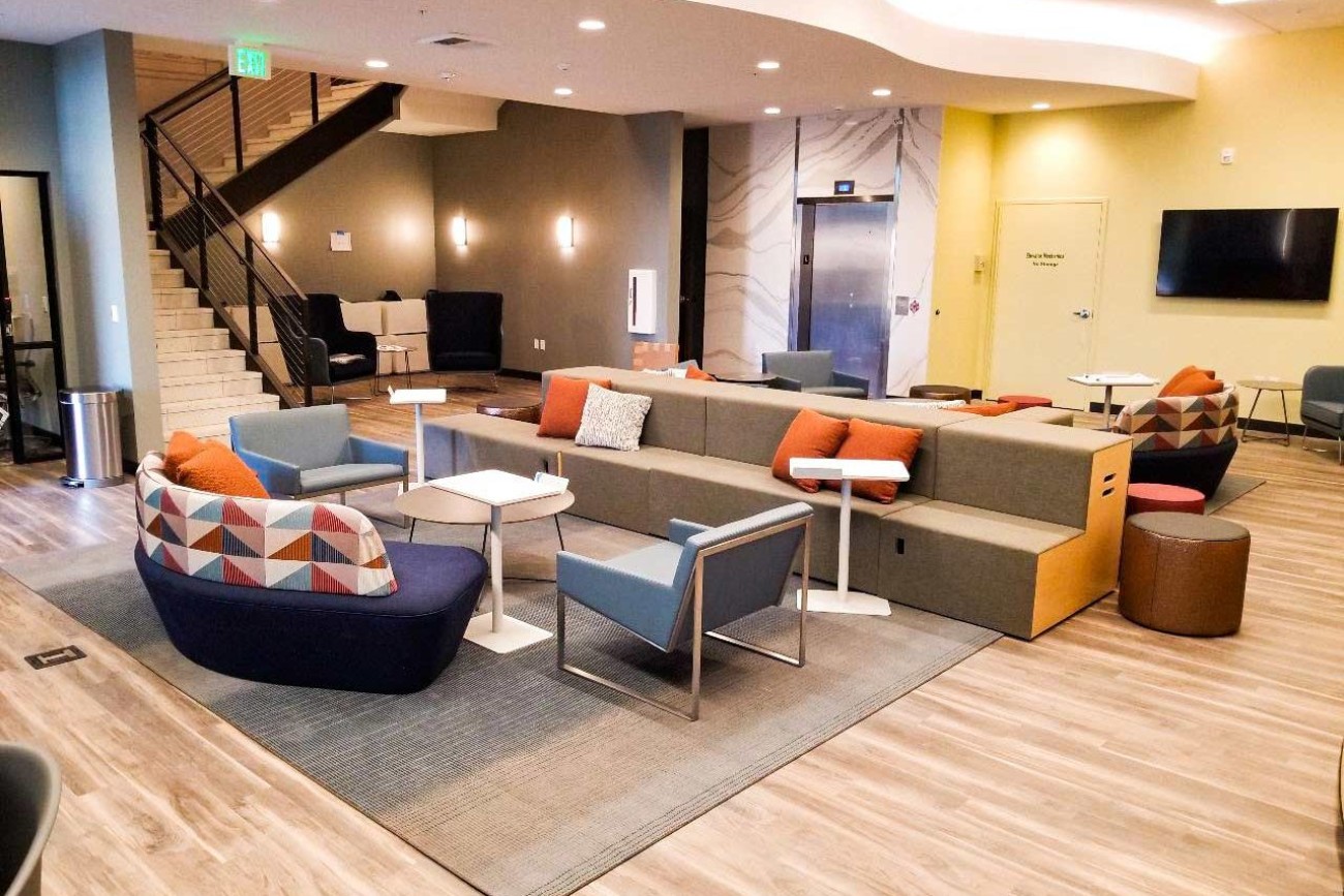 Modern commercial common area and collaboration space with lounge seating and meeting areas.